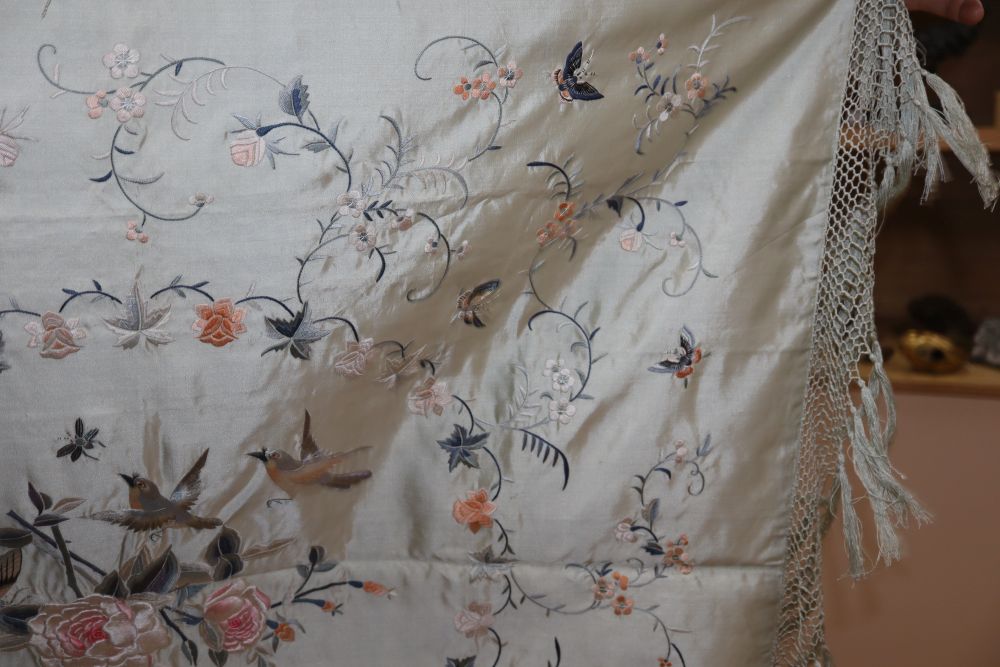 A late 19th century Chinese embroidered and fringed cover, decorated with flowers and butterflies on a pale turquoise background